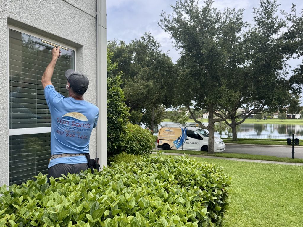 Sun Sands technician cleaning a window in Windermere, FL