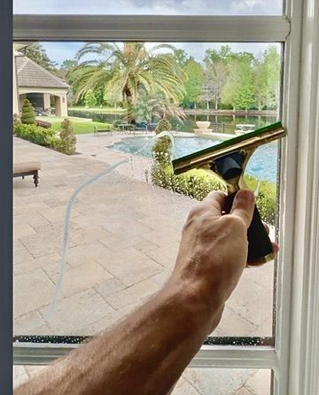 Sun Sands technician cleaning a window in Windermere, FL