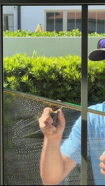 Sun Sands technician cleaning a window in Windermere, FL