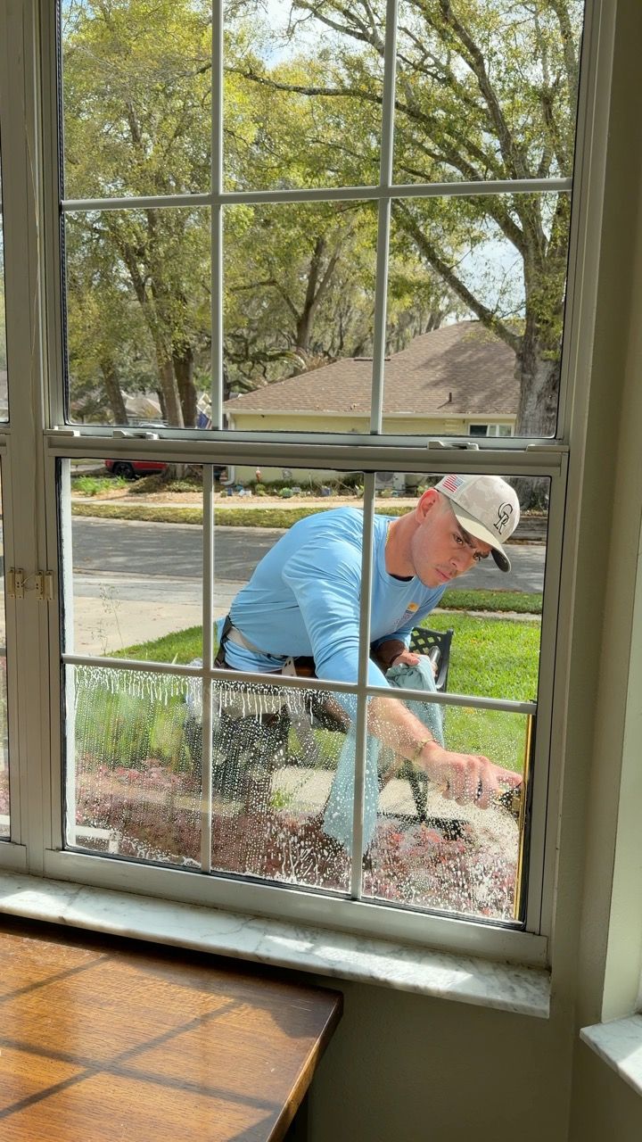 Sun Sands technician cleaning a window in Windermere, FL